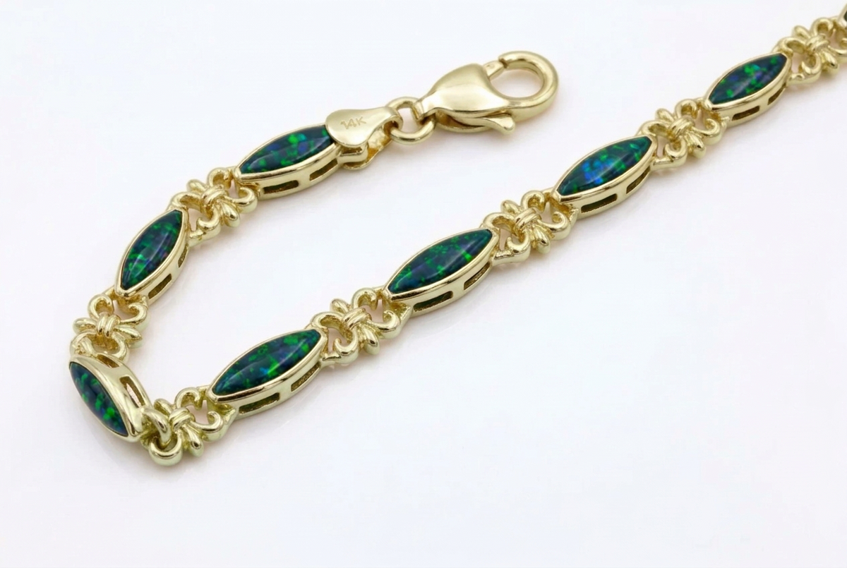 A silver tennis bracelet featuring marquise-cut green opal stones and silver filigree links, displayed on a clean white background.